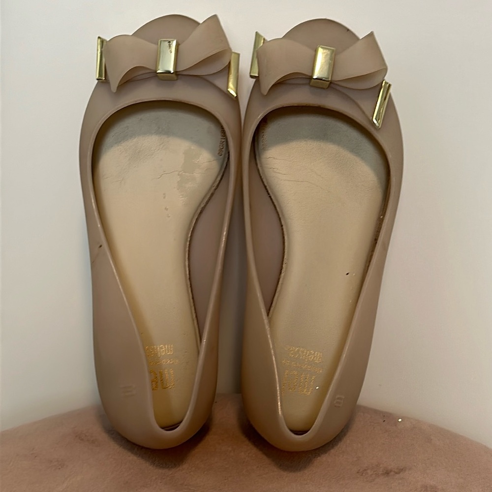Mel by Melissa flats with taupe and gold bow accent in size one.
